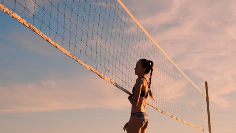 Beachvolleyball-Match-Mädchen-Schlagen-Den-Ball-In-Zeitlupe-Bei-Sonnenuntergang-Auf-Dem-Sand